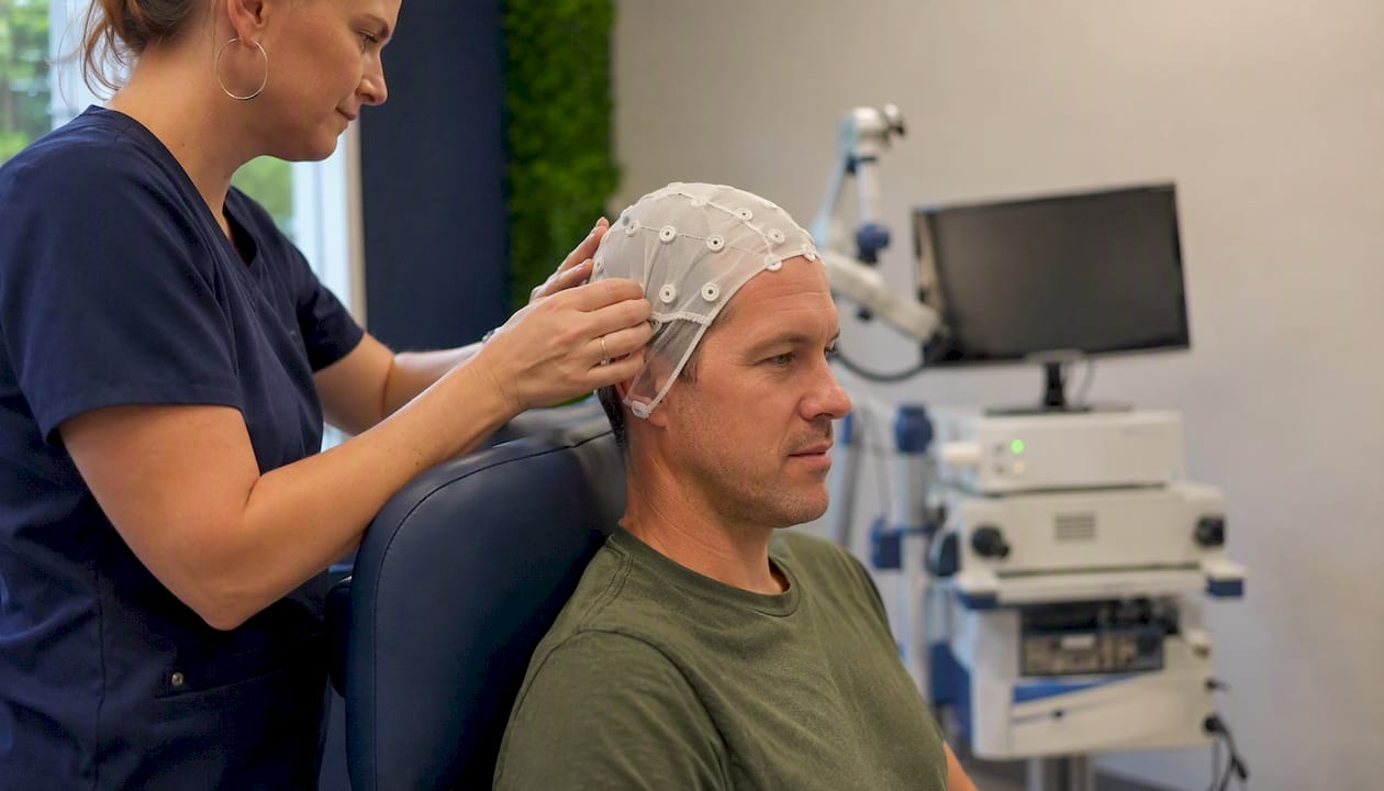 Technician placing scalp measurement cap for TMS