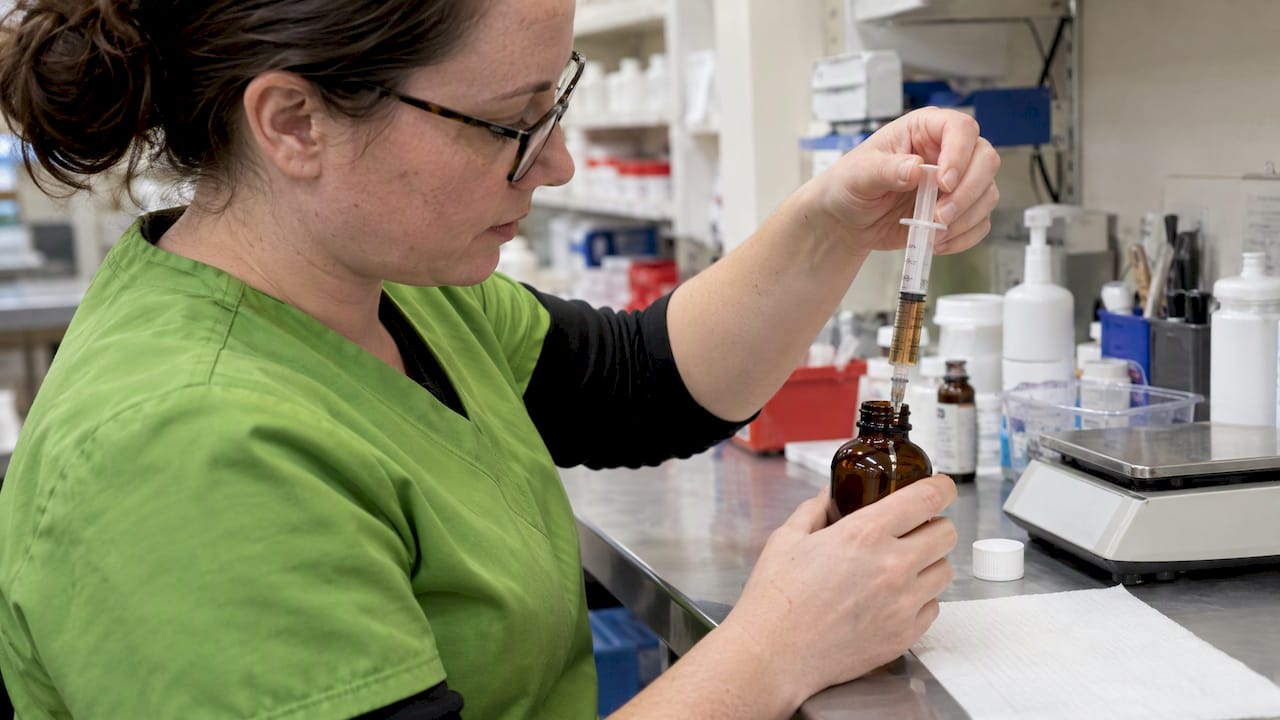Pharmacist measuring a liquid medication dose