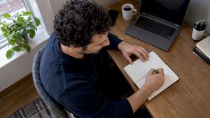 Adult recording a mood observation in a notebook